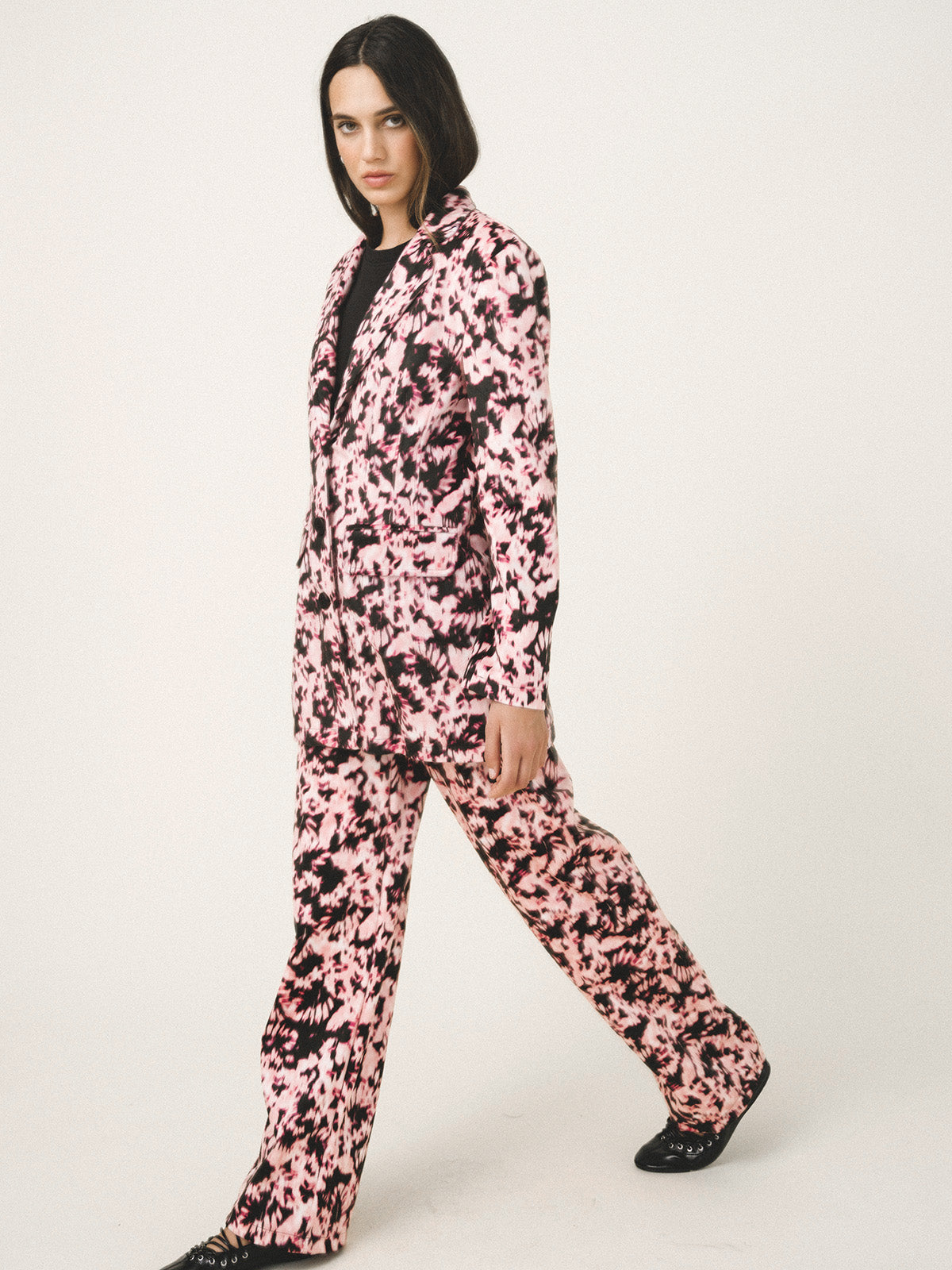 Person wearing a pink and black patterned outfit on a white background