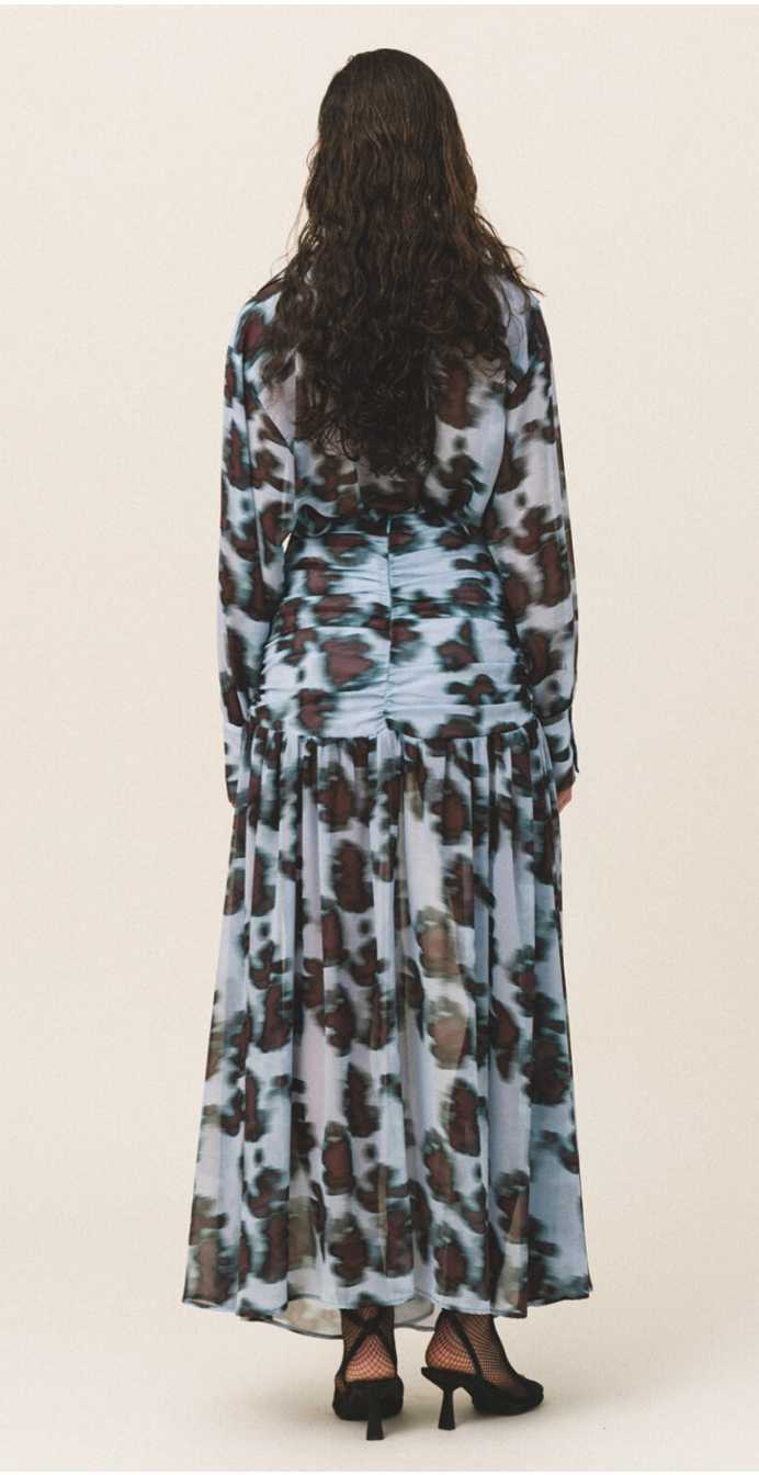 woman with oversized sheer shirt with a geometric animal pattern back-sided.