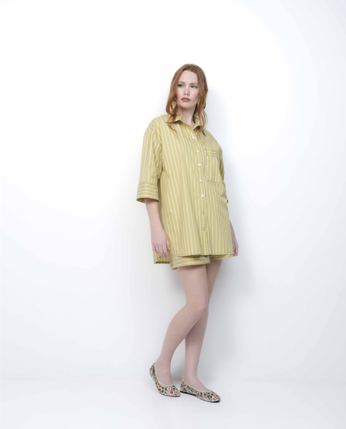 Woman wearing a yellow striped shirt and shorts on a white background