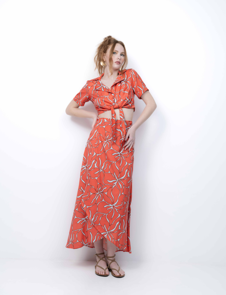 Woman wearing a red patterned dress on a white background