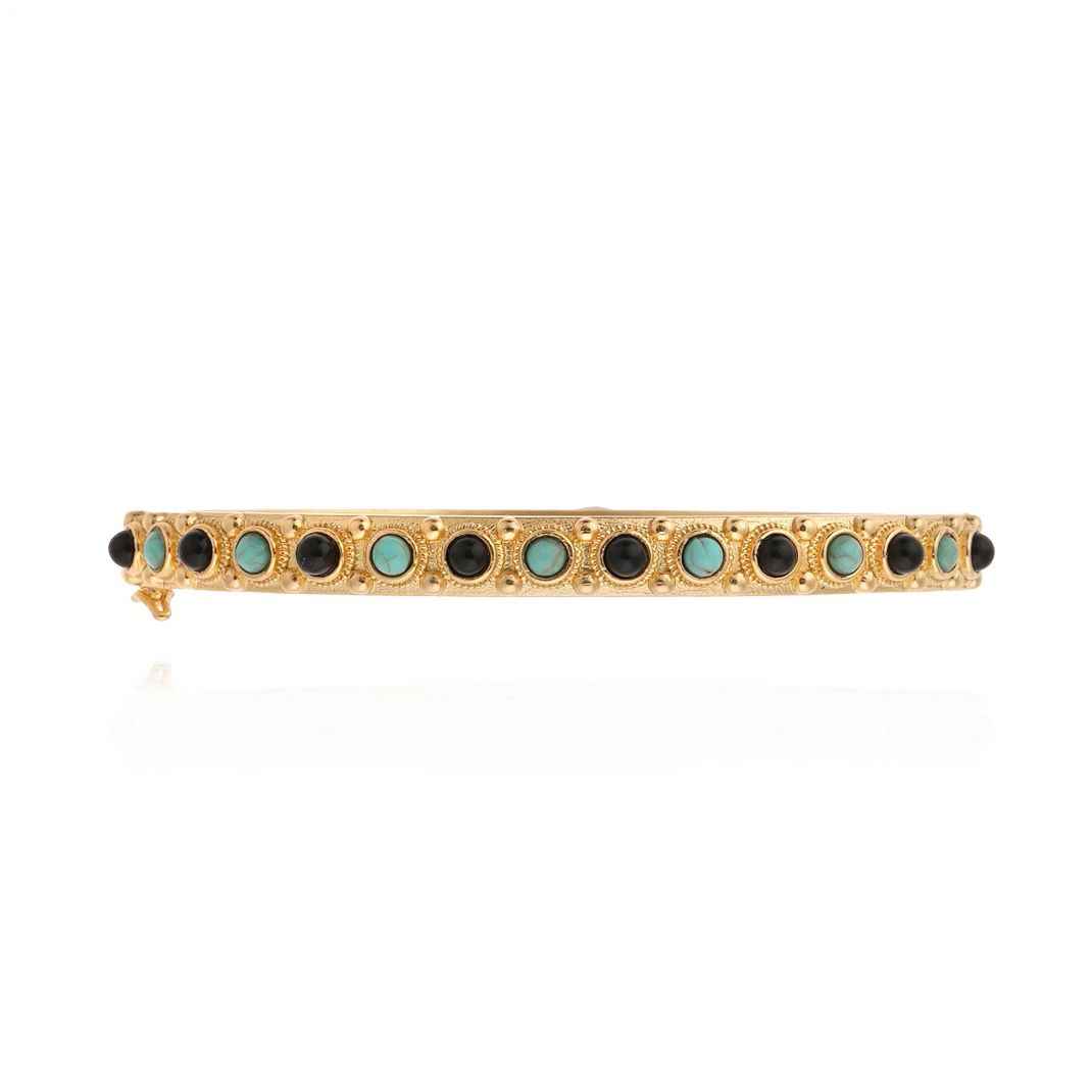 Gold bracelet with black and turquoise stones on a white background