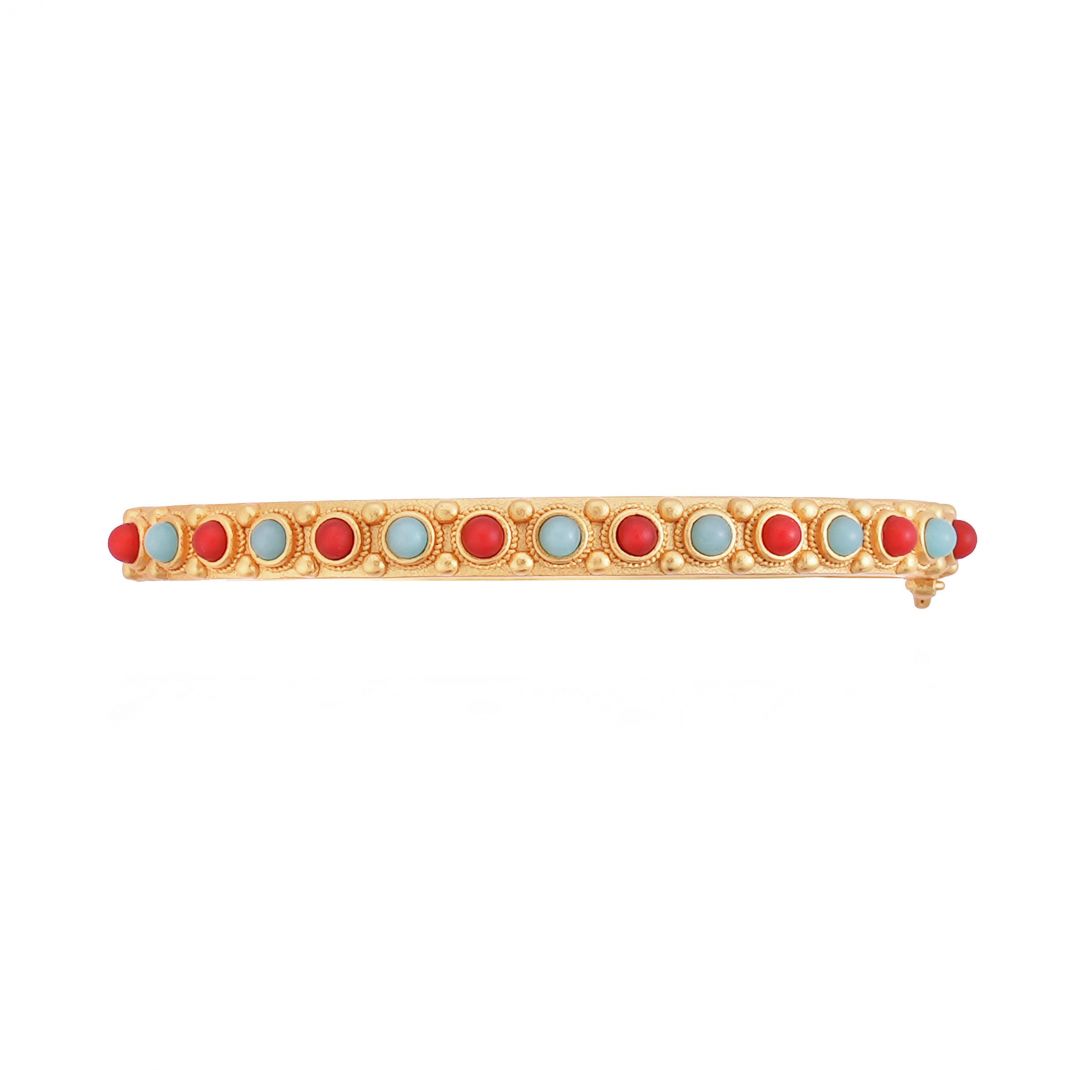 Gold bracelet with red and blue stones on a white background