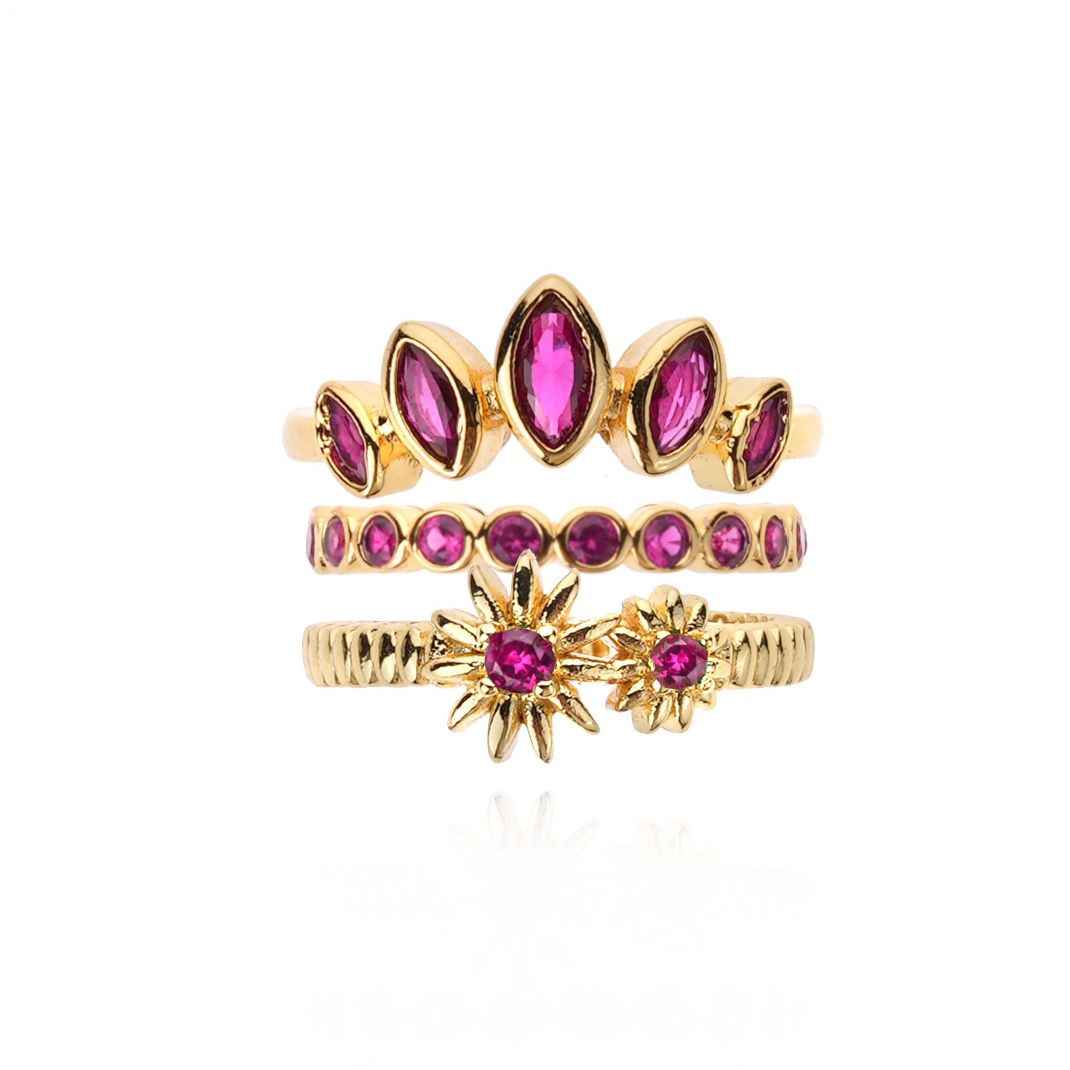 Set of gold and pink gemstone rings on a white background