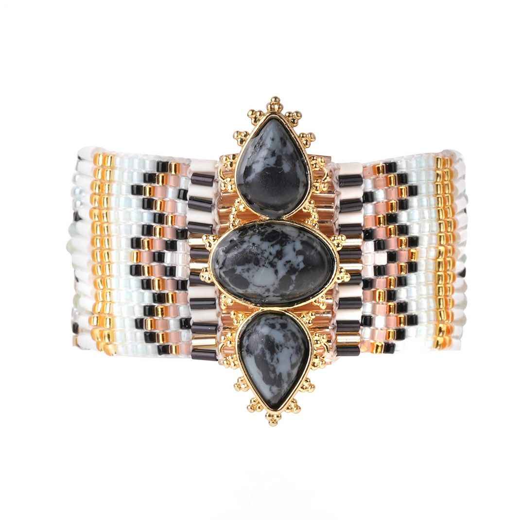 Beaded bracelet with black teardrop stones on a white background