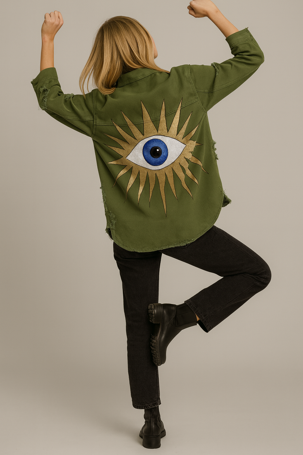 Person wearing a green jacket with a sun and eye design, standing against a plain background