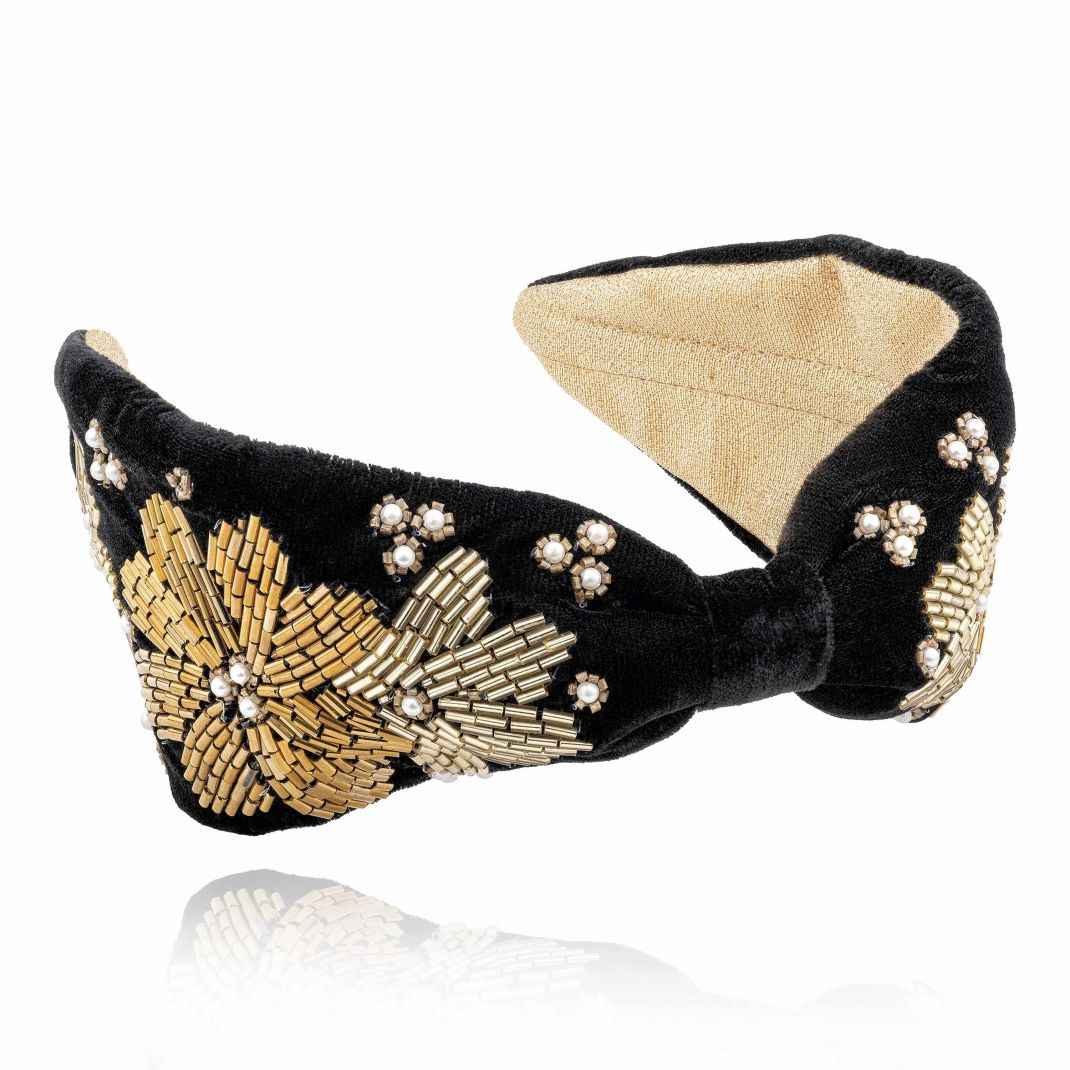 Black headband with gold embellishments on a white background