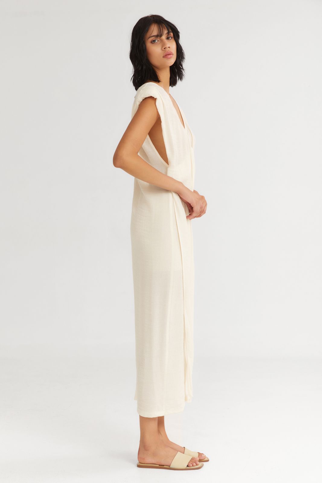 Woman wearing a white sleeveless jumpsuit on a white background