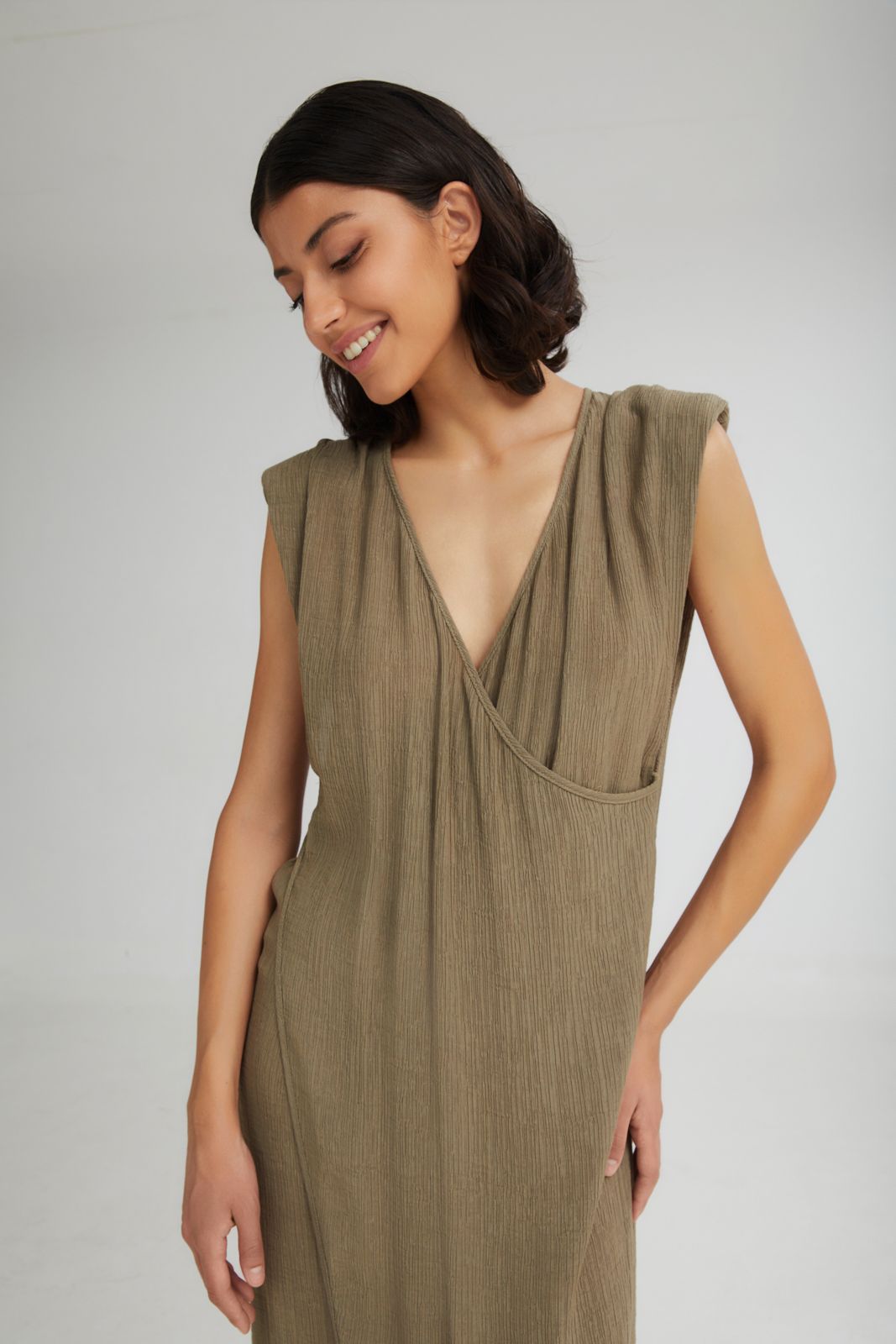 Woman wearing a green dress against a plain background