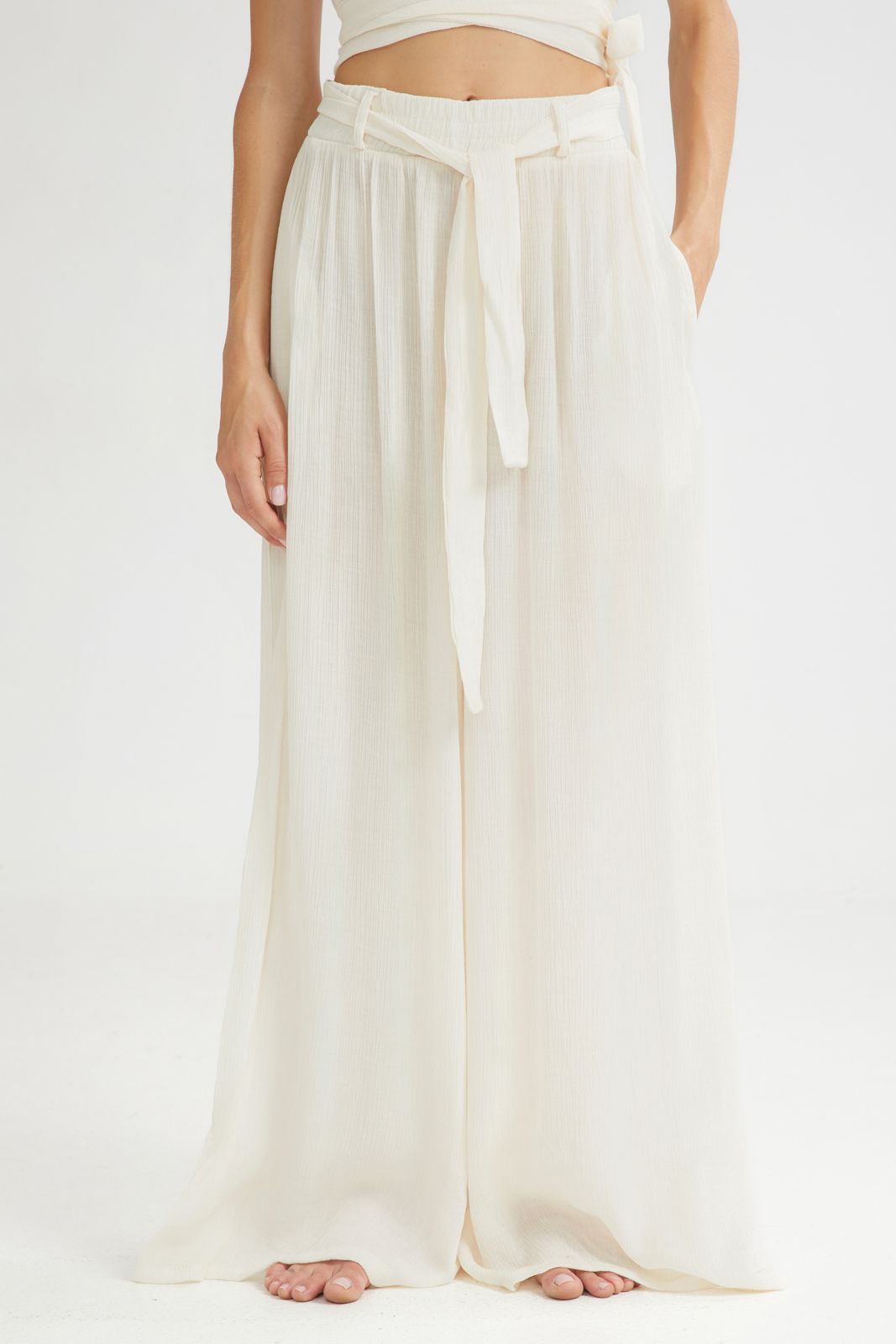 White wide-leg pants with a belt on a white background