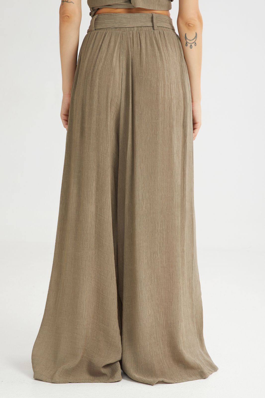 Person wearing a pair of wide-leg pants on a white background