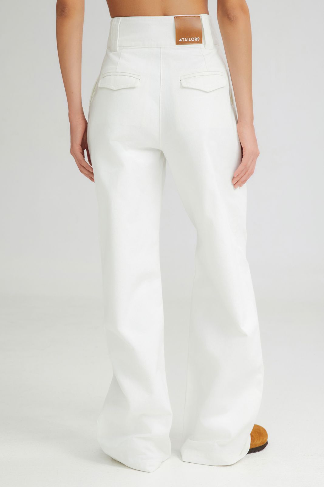White pants worn by a person on a white background