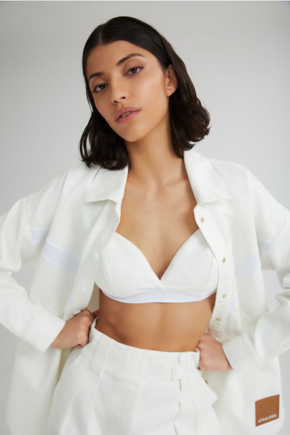 Woman wearing a white outfit with a plain background