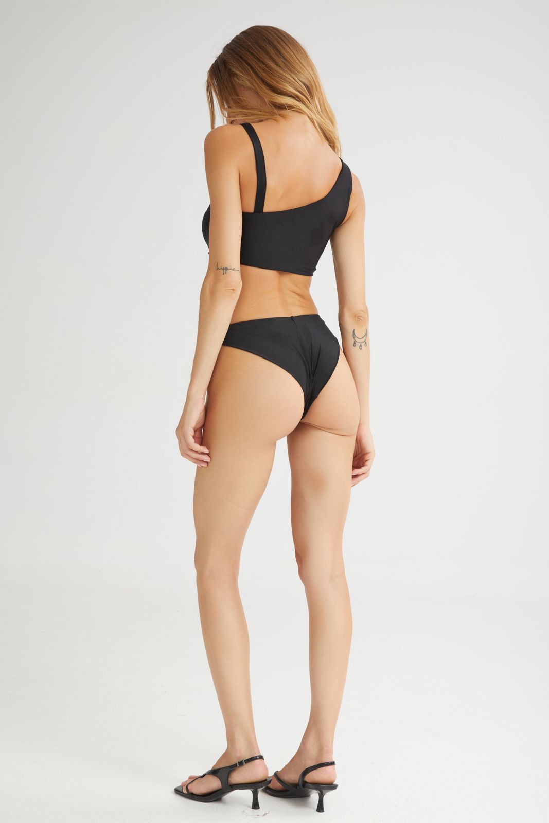 Woman wearing a black bikini set on a white background