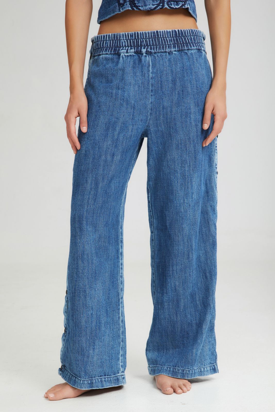 Blue denim wide-leg pants worn by a person on a white background