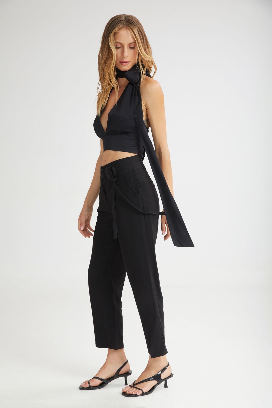 Woman wearing a black outfit with a scarf on a white background