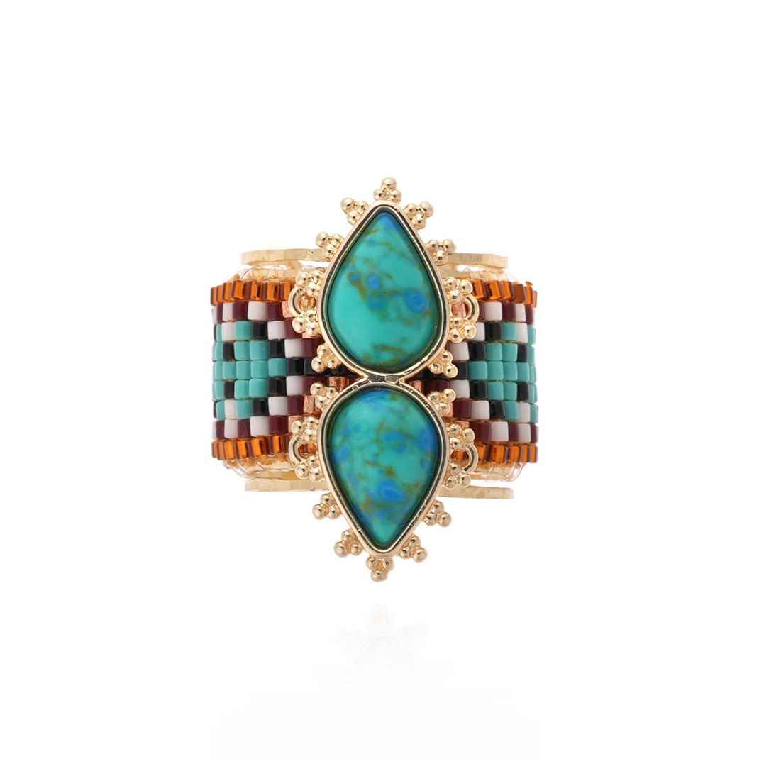 Multicolored beaded cuff bracelet with turquoise stones on a white background