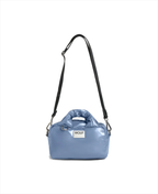 A light blue puffer-style shoulder bag with a black shoulder strap and a white brand label reading 'WOOF' on the front, shown on a plain white background.