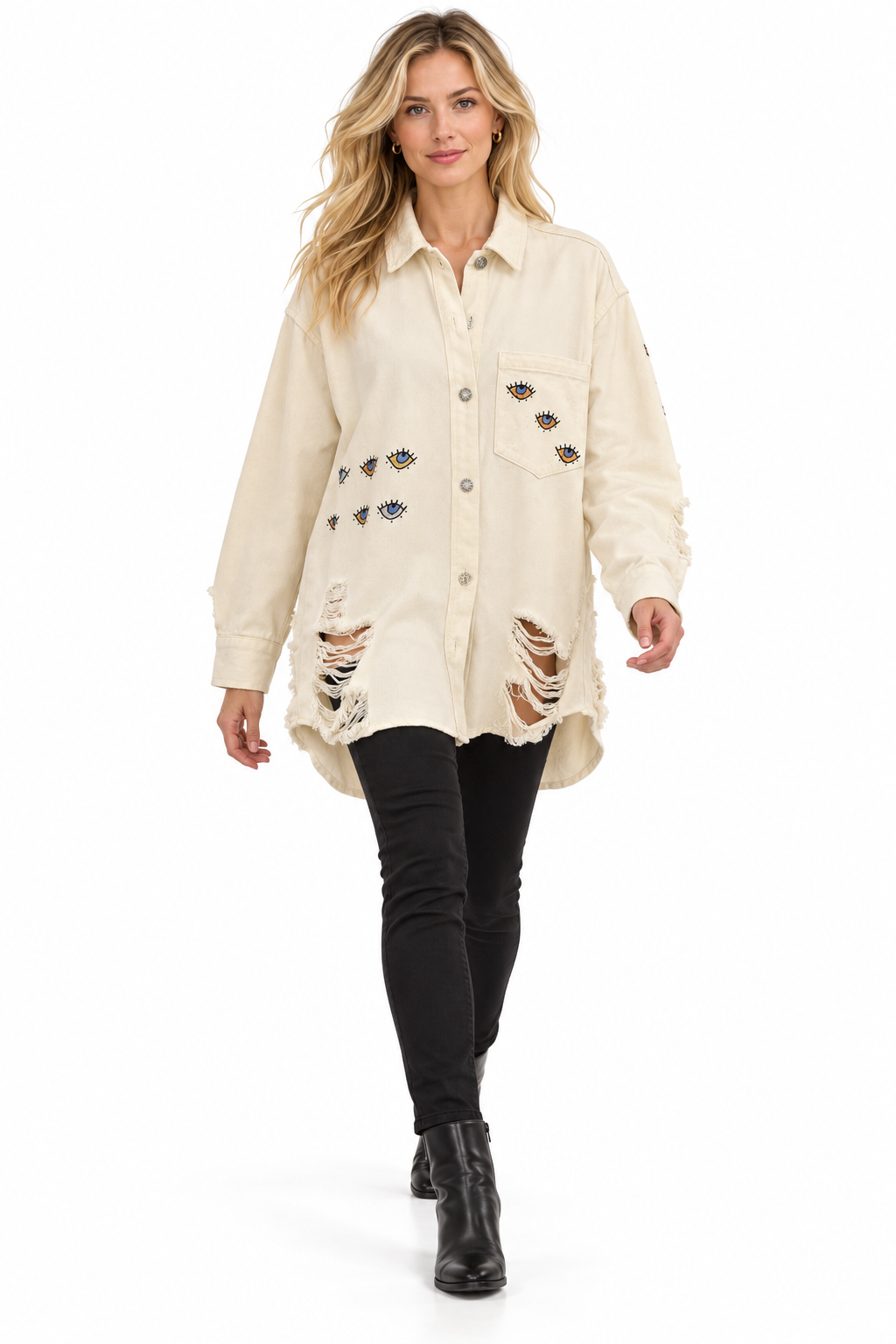A woman modeling a distressed off-white button-up shirt jacket with embroidered details, paired with black skinny jeans and black ankle boots, on a solid white background.