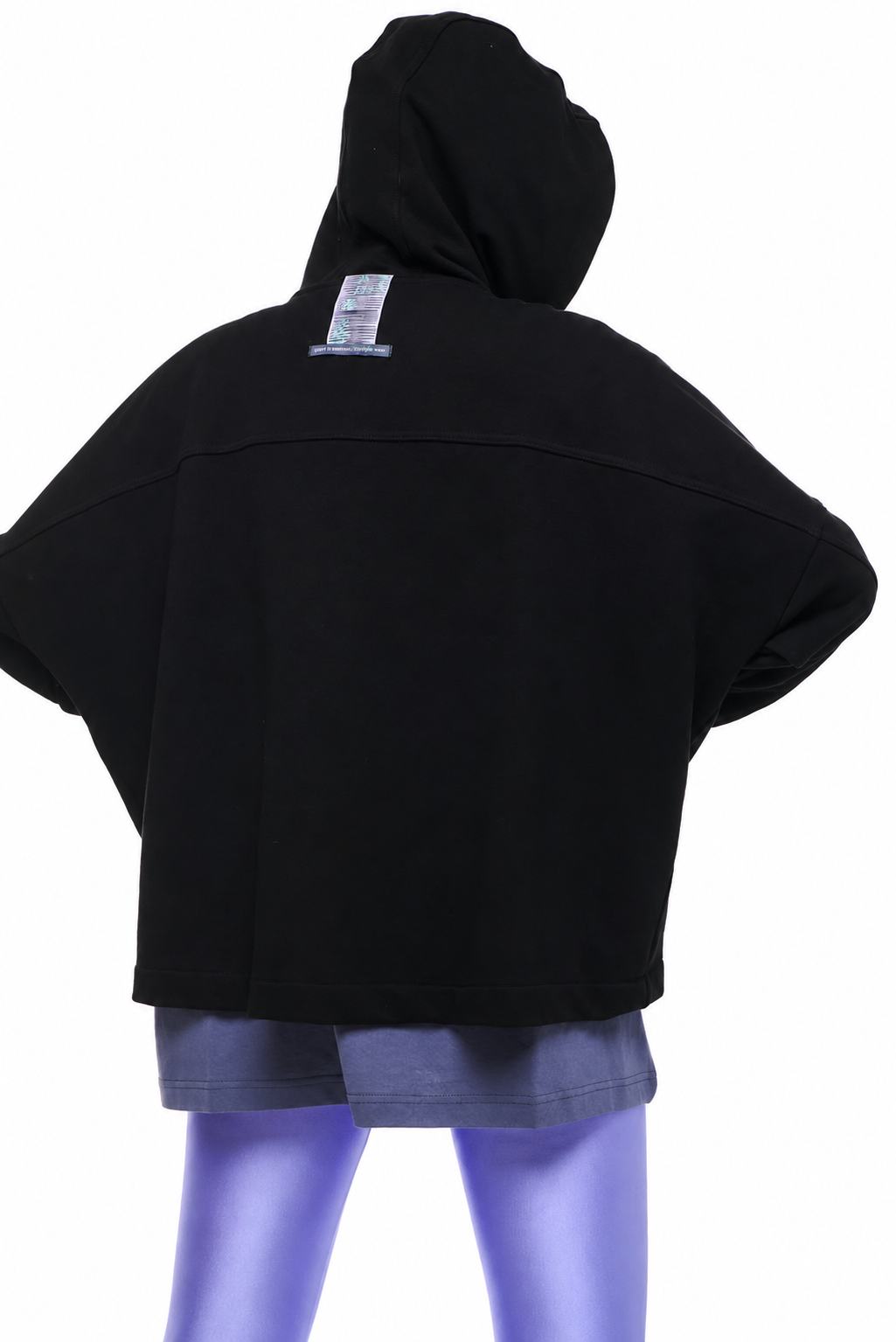 A black cropped hooded sweatshirt shown from the back on a mannequin, paired with gray shorts and purple leggings against a plain white background.