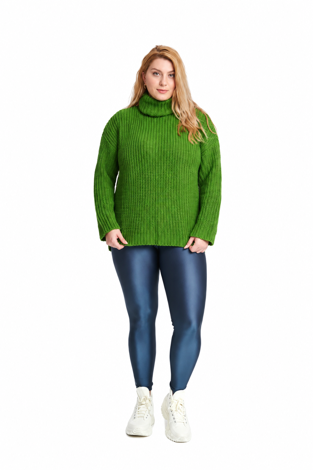A woman modeling a bright green ribbed turtleneck sweater, paired with dark blue leggings and white sneakers, against a solid white background.