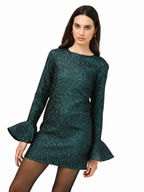 A woman modeling a dark teal green long-sleeve mini dress with a textured, glittery pattern and flared bell sleeves, paired with sheer black tights against a plain white background.