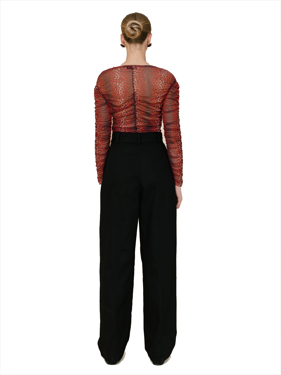 A model viewed from the back wearing a sheer red lace long-sleeve top with a gathered back and black wide-leg trousers, set against a plain white background.