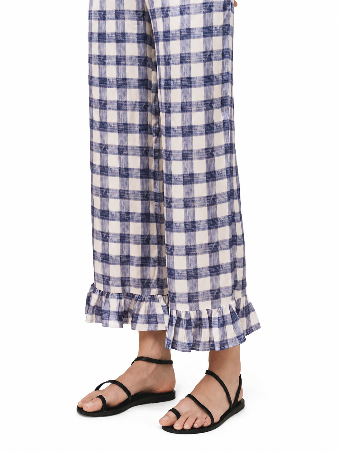 A person wearing wide-leg cropped pants with a blue and white gingham pattern and ruffled hems, styled with black flat sandals against a plain white background.