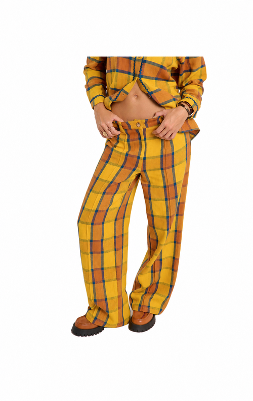A person wearing yellow plaid pants and a matching yellow plaid shirt, shown from the waist down against a plain white background.