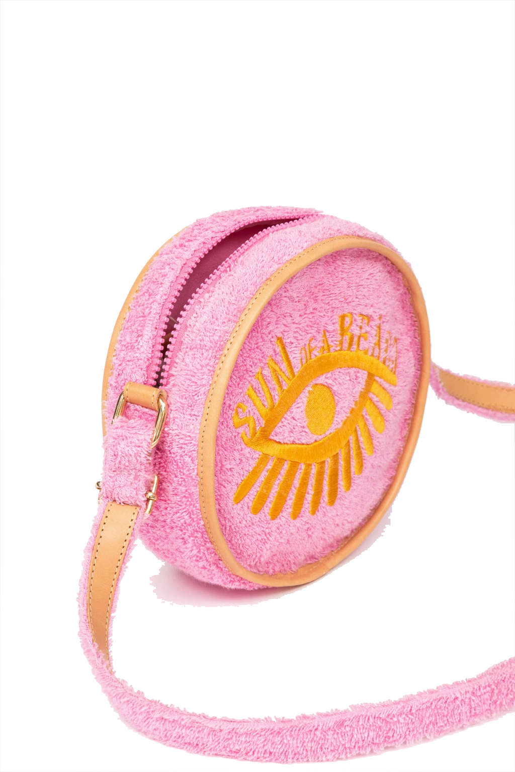 A pink textured crossbody bag with a yellow embroidered eye and the words 'SUN OF A BEACH' on the front, featuring tan leather trim and strap.