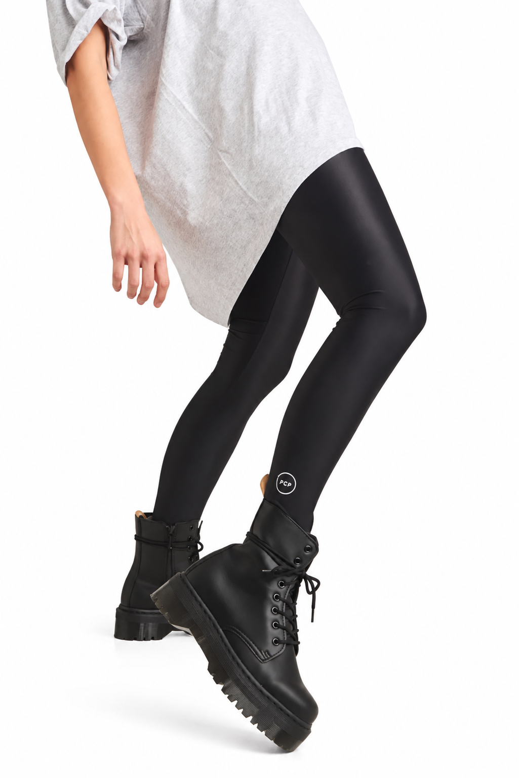 A model wearing black full-length leggings and chunky black lace-up ankle boots, cropped from the waist down against a plain white studio background.