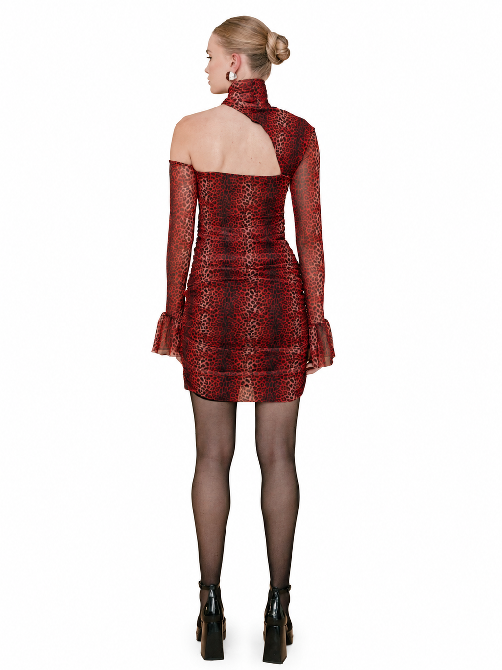 A model shown from the back wearing a red and black snakeskin-patterned mini dress with sheer long sleeves and a high mock neck, paired with black tights and black platform ankle boots, against a solid white background.