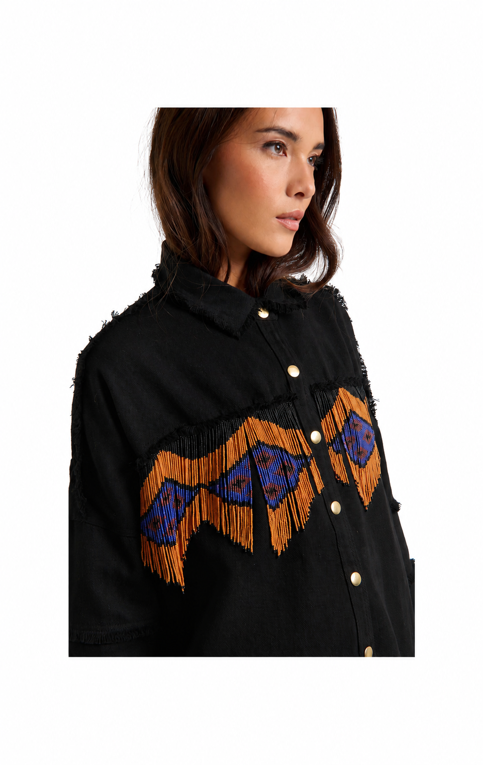 A woman wearing a black fringed button-up shirt with a prominent geometric pattern across the chest in orange and blue, photographed against a plain white background.