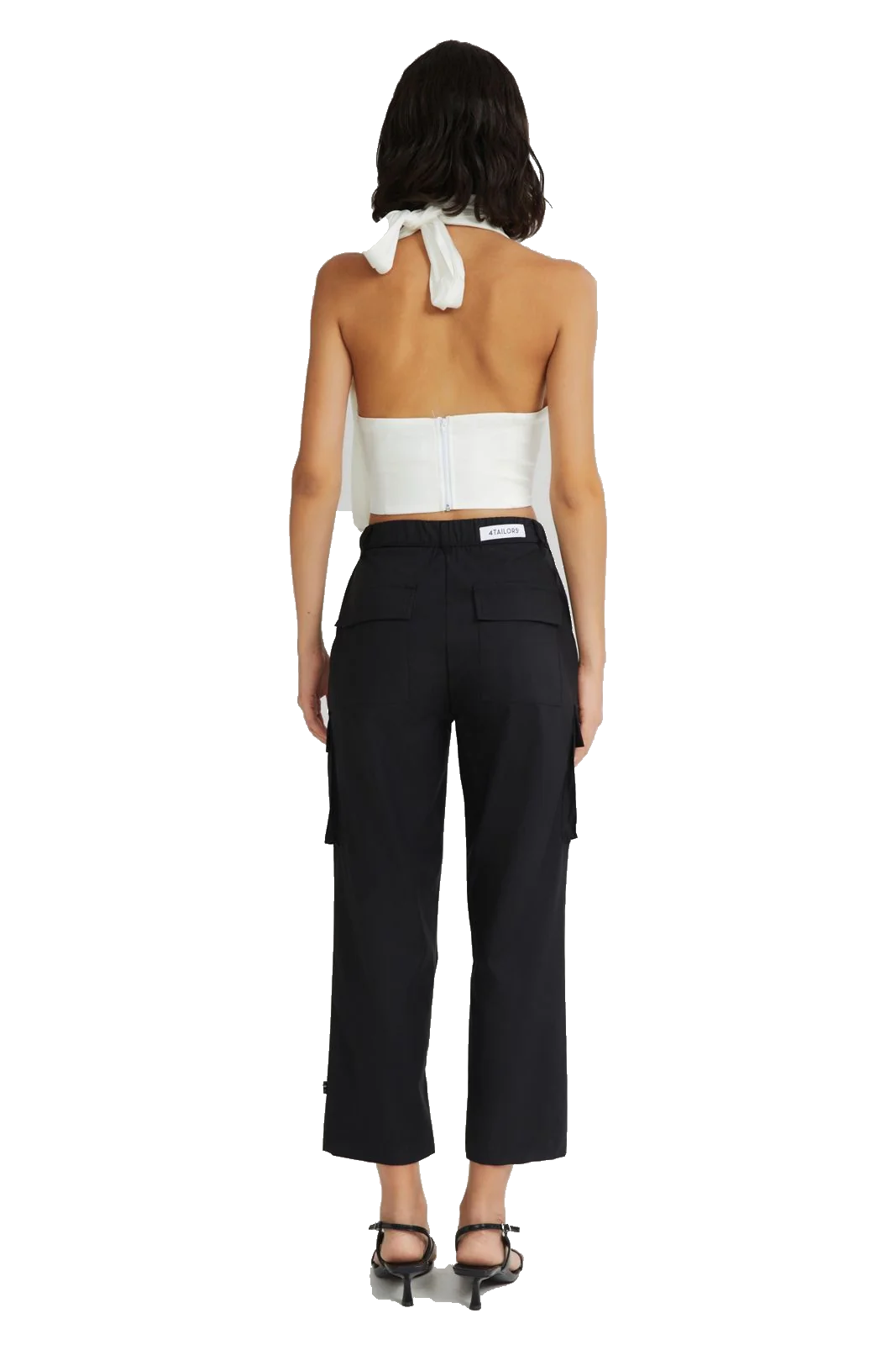 A model shown from the back wearing a white halter crop top and black cropped cargo pants, paired with black heeled sandals, against a plain white background.