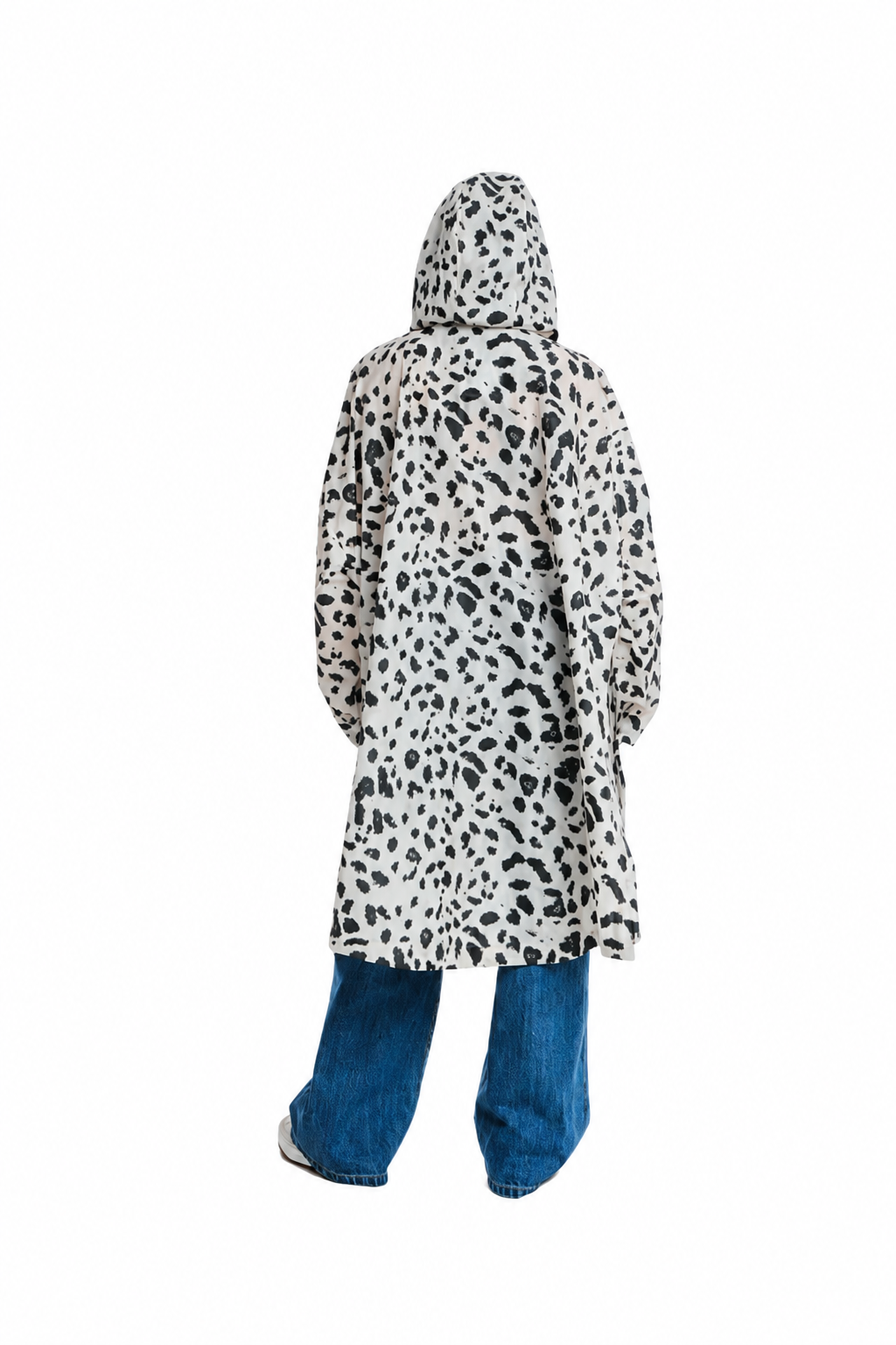 A person shown from the back wearing a hooded long coat with a black irregular spotted pattern on a white base, paired with blue jeans, against a plain white background.