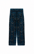 A pair of wide-leg trousers in dark teal blue velvet with an intricate gold and silver beaded geometric pattern, shown flat against a solid white background.