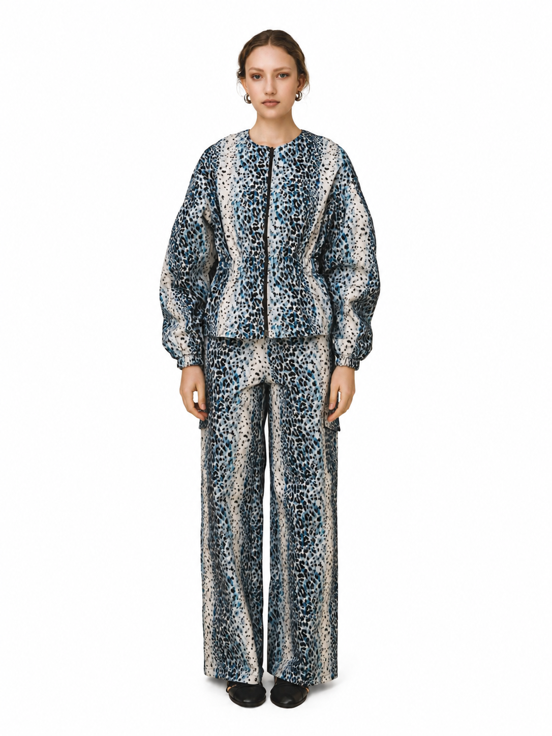 A model stands against a plain white background wearing a matching two-piece outfit consisting of a cropped jacket and wide-leg trousers, both featuring a blue, black, and beige animal print.