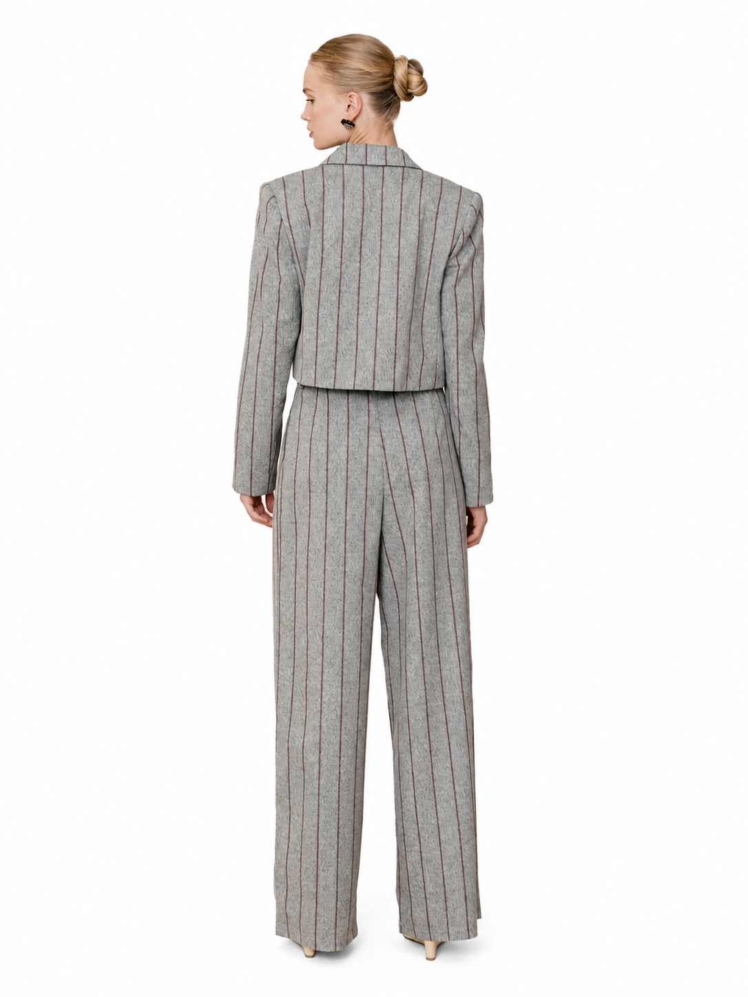 A woman shown from the back wearing a gray pinstripe cropped blazer and matching wide-leg trousers, photographed against a plain white studio background.