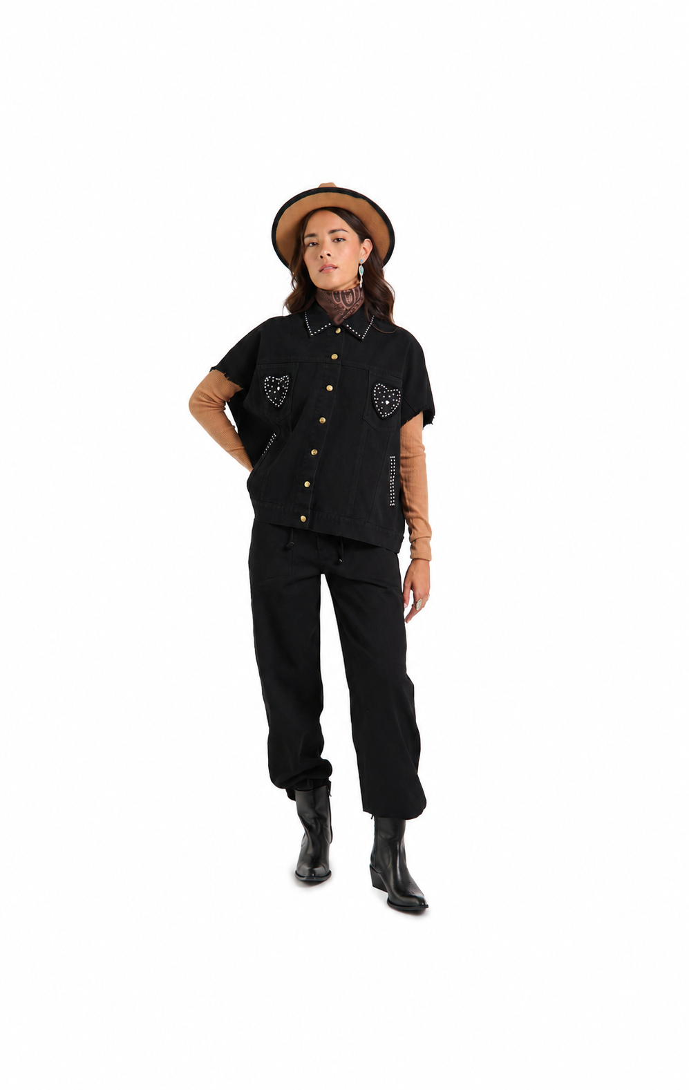 A model wearing a black short-sleeve button-up shirt with embroidered chest details, black pants, black boots, and a tan hat, standing against a plain white background.