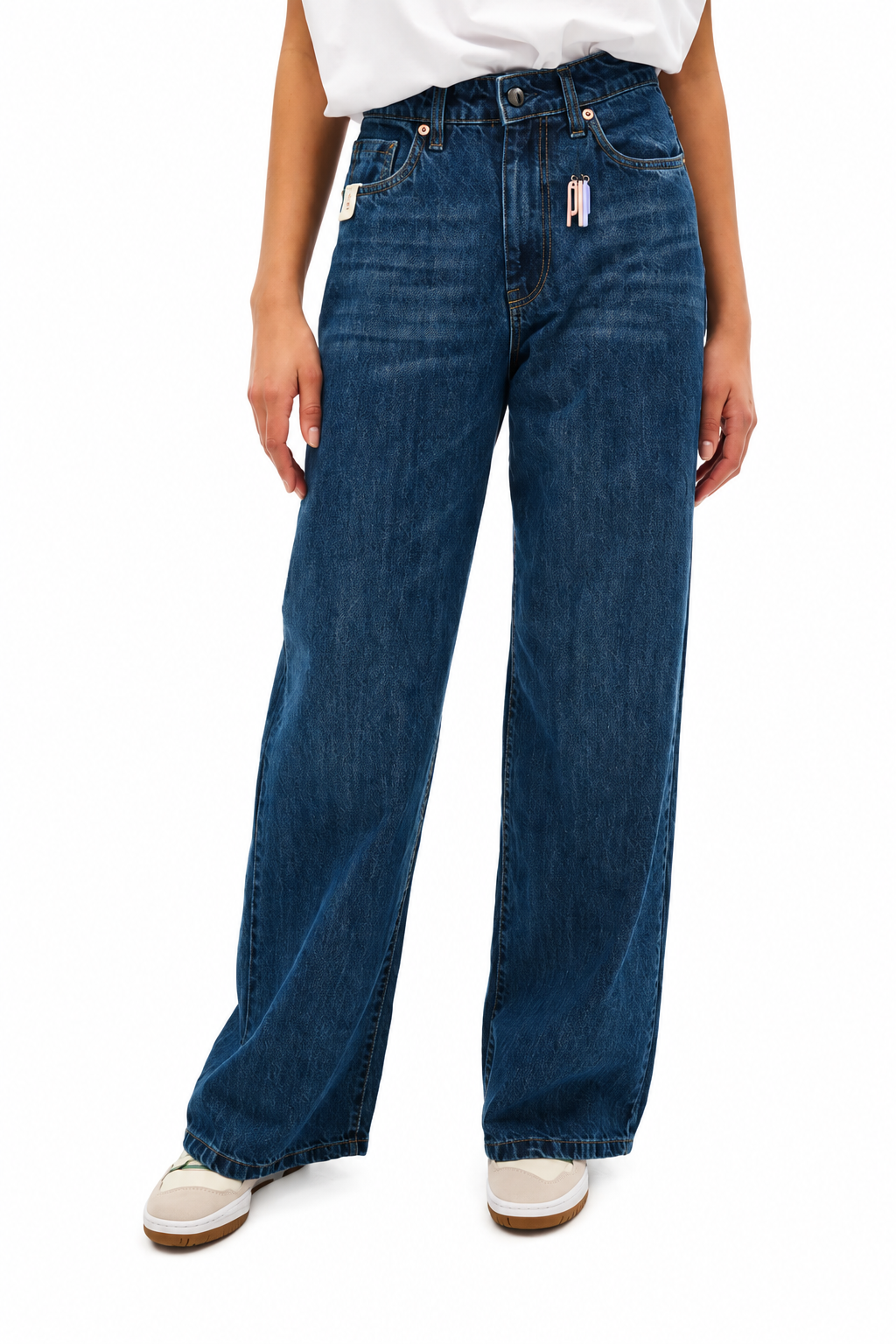 A person wearing high-waisted, wide-leg blue denim jeans with a white top and white sneakers, shown from the waist down against a plain white background.