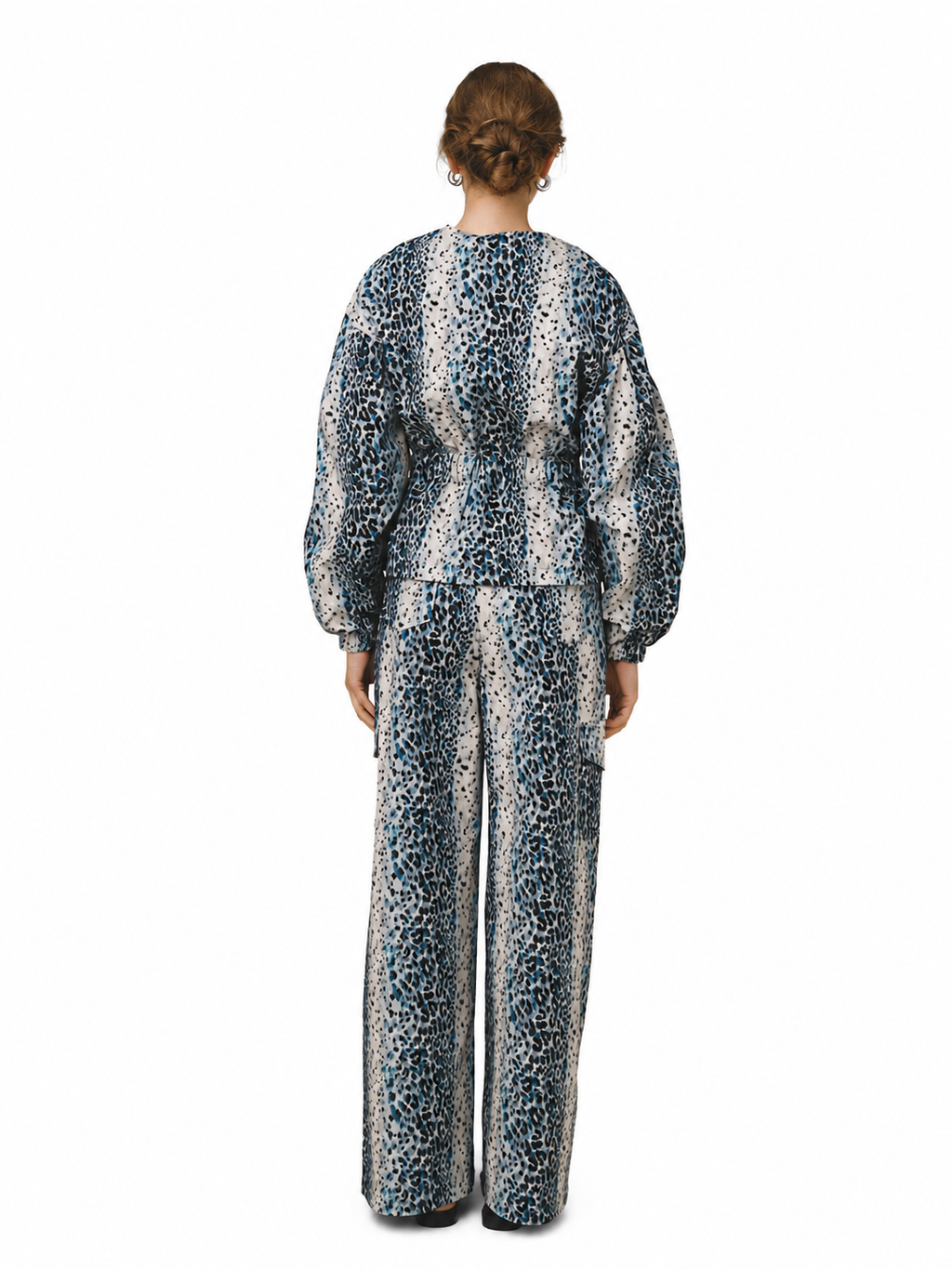 A model viewed from the back wearing a matching long-sleeve top and wide-leg trousers set in a blue, black, and white leopard print pattern, set against a plain white background.