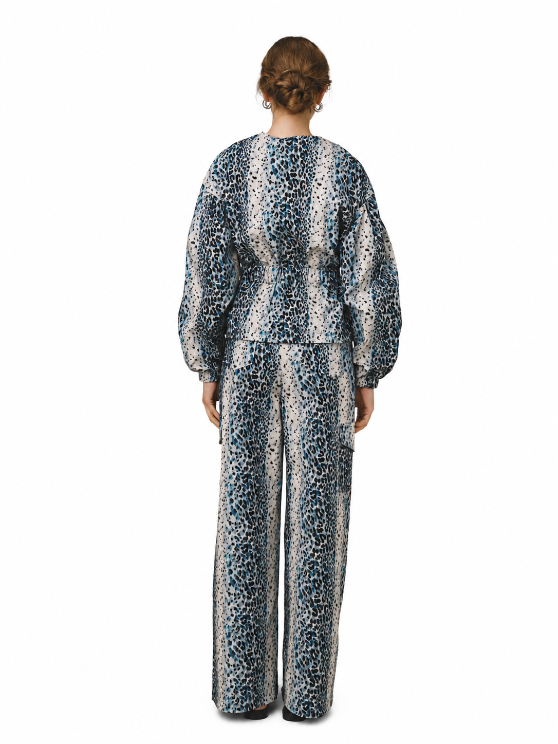 A model viewed from the back wearing a matching long-sleeve top and wide-leg trousers set in a blue, black, and white leopard print pattern, set against a plain white background.