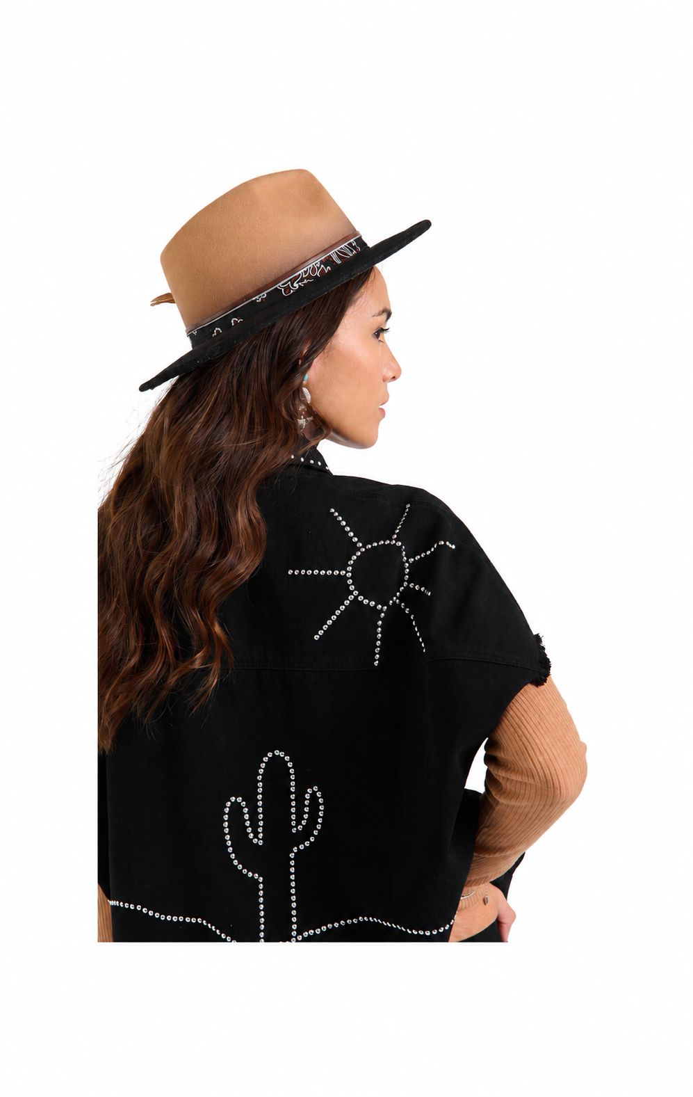 A woman shown from the back wearing a black poncho with white studded sun and cactus designs, a tan hat, and a beige ribbed long-sleeve shirt, against a plain white background.