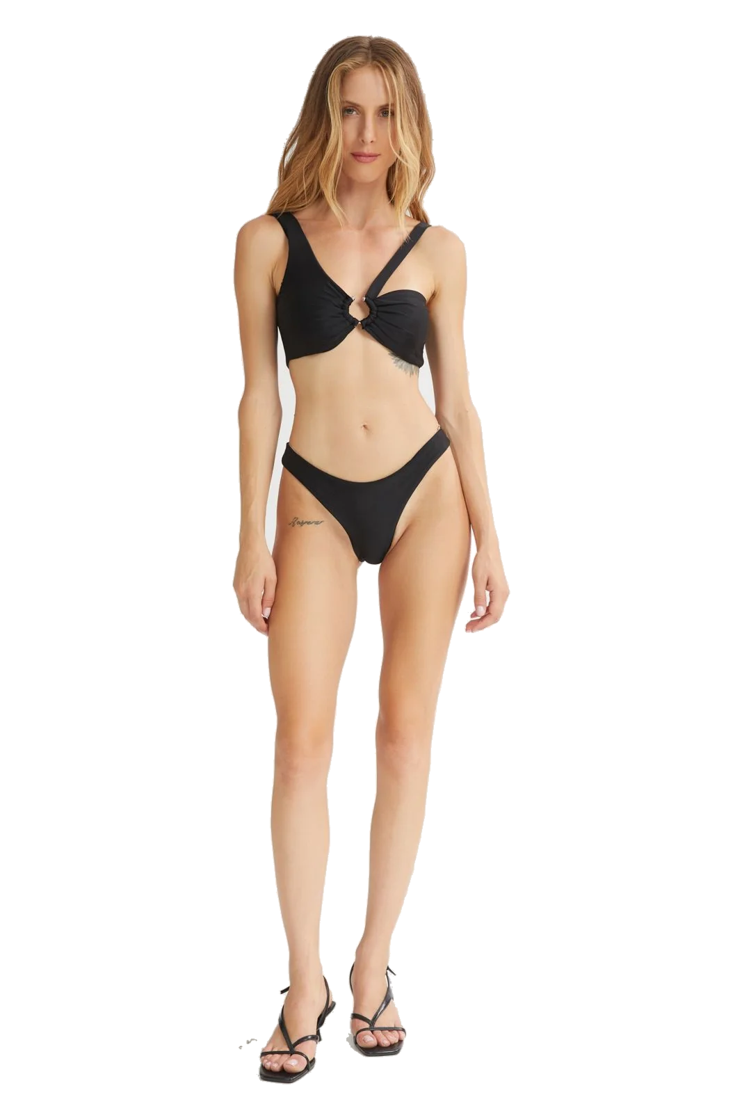 A woman modeling a black two-piece bikini with a halter-style top featuring a front knot detail and matching high-cut bottoms, paired with black strappy heels against a plain white background.