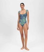 Woman wearing a blue and green patterned one-piece swimsuit on a white background