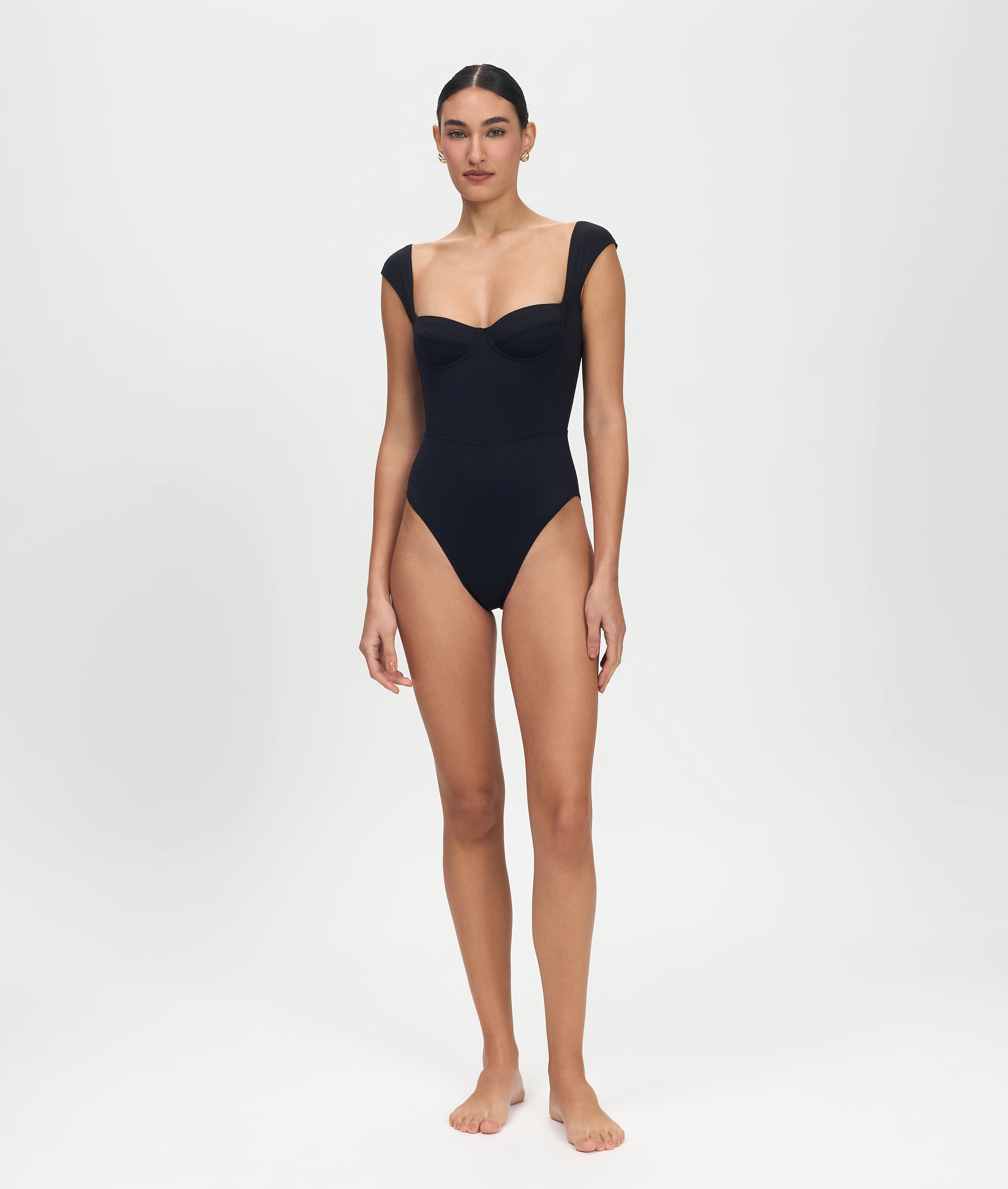 Woman wearing a black swimsuit on a white background