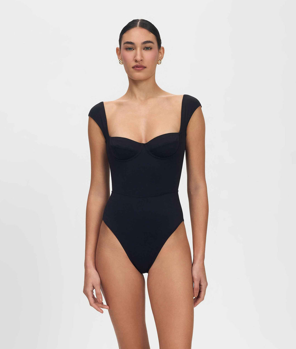 Woman wearing a black swimsuit on a white background