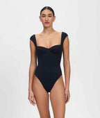 Woman wearing a black swimsuit on a white background