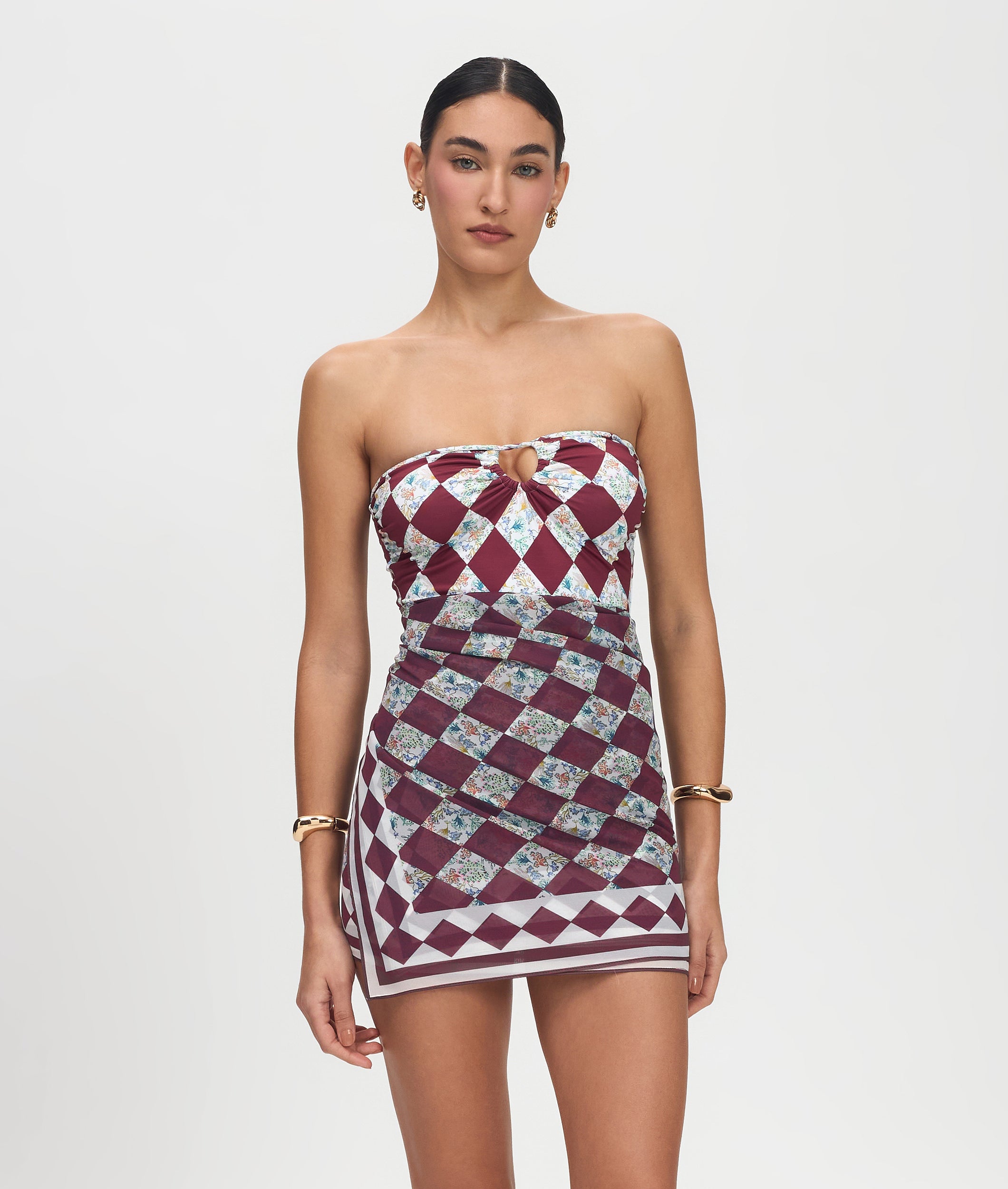 Woman wearing a strapless dress with a geometric pattern on a plain background