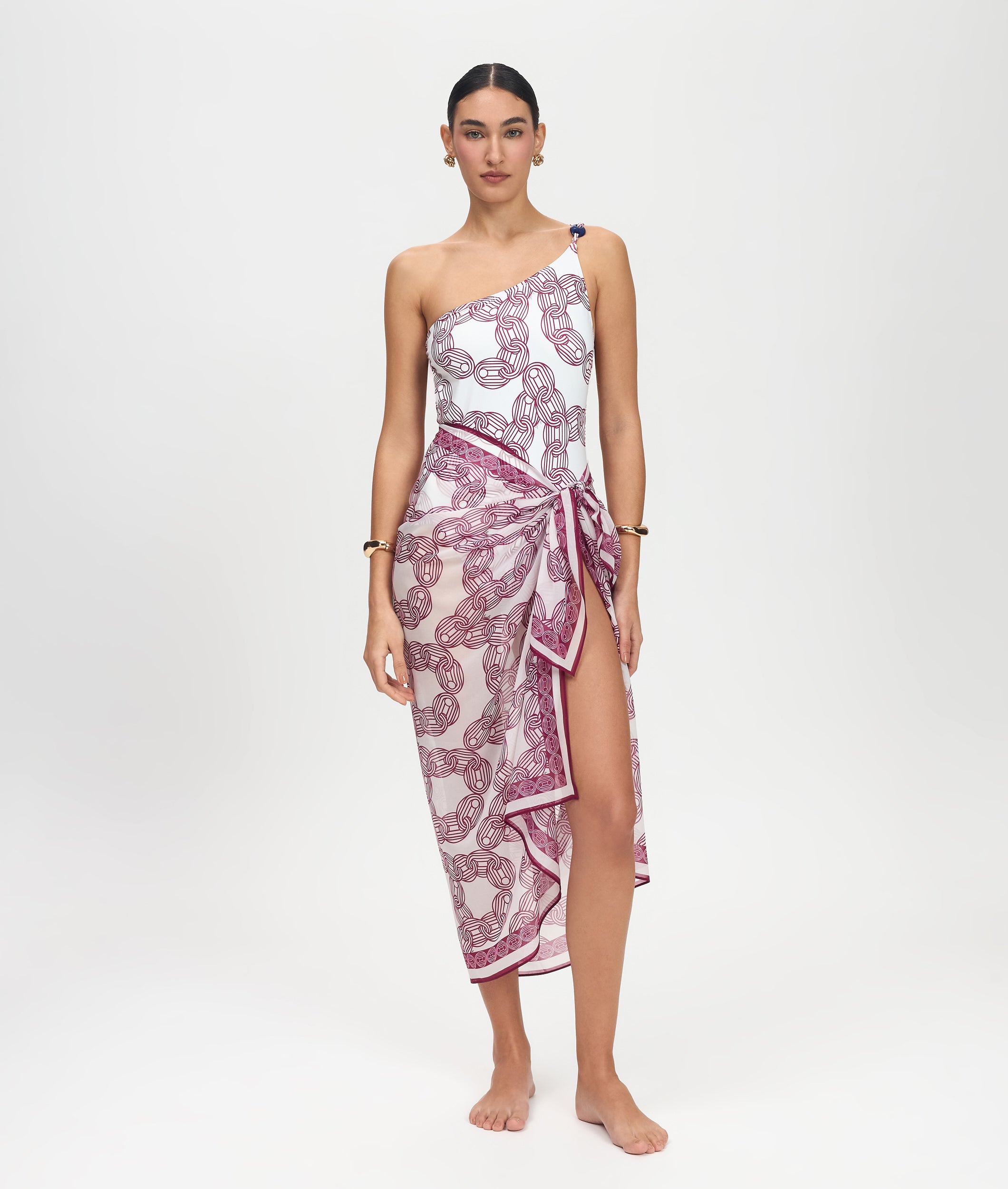 Woman wearing a one-shoulder dress with a pink and white pattern on a white background