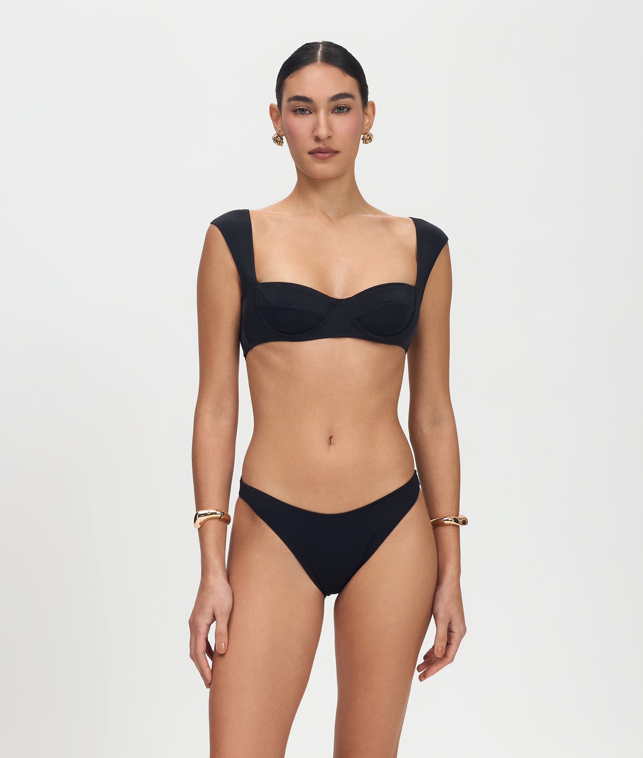 Woman wearing a black bikini on a light gray background